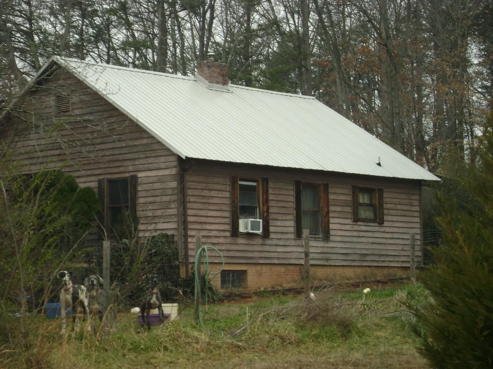 White metal roof on an old wood sided farmhouse, from a Metal Roof Installation job in Donahue